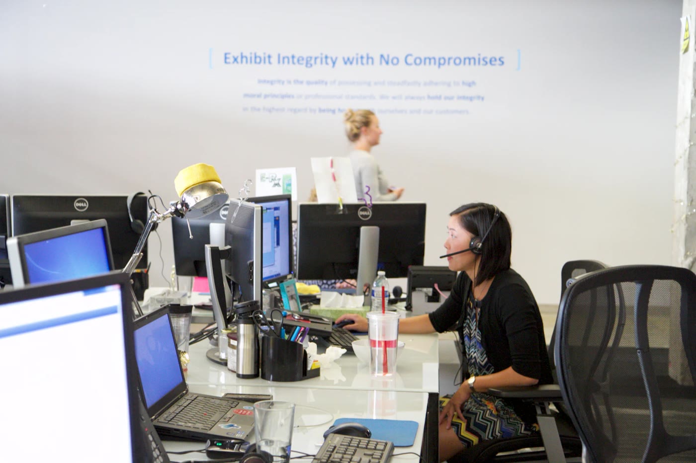 A customer support agent on a headset call at her desk